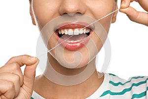 Young woman flossing her teeth on white background, closeup. Cosmetic dentistry