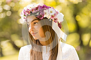 Young woman with flowers in her hair on sunny spring day