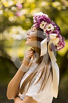 Young woman with flowers in her hair on sunny spring day