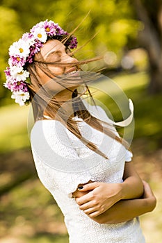 Young woman with flowers in her hair on sunny spring day