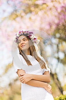 Young woman with flowers in her hair on sunny spring day