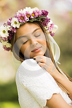 Young woman with flowers in her hair on sunny spring day