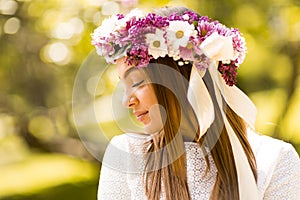 Young woman with flowers in her hair on sunny spring day