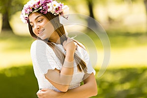 Young woman with flowers in her hair on sunny spring day