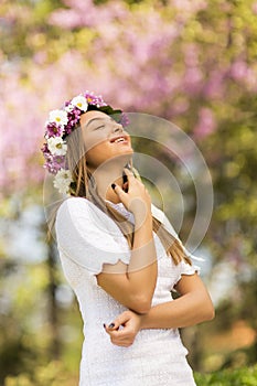 Young woman with flowers in her hair on sunny spring day