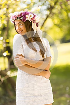 Young woman with flowers in her hair on sunny spring day