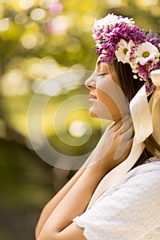 Young woman with flowers in her hair on sunny spring day