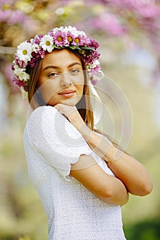 Young woman with flowers in her hair on sunny spring day