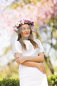 Young woman with flowers in her hair on sunny spring day