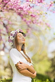 Young woman with flowers in her hair on sunny spring day