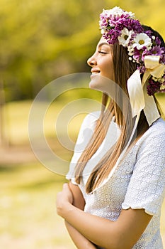 Young woman with flowers in her hair on sunny spring day