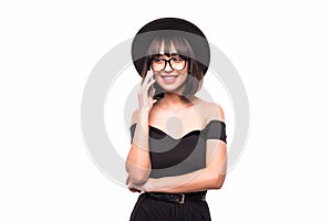 Young woman in fluppy black hat and black clothes talk on phone on white background