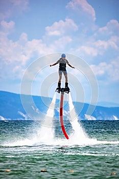 Young woman is flying at the aquatic flyboard