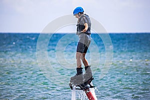 Young woman is flying at the aquatic flyboard