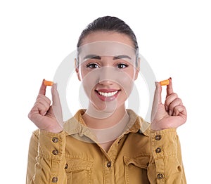 Young woman with foam ear plugs on white background