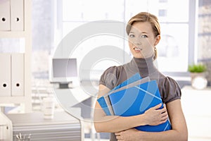 Young woman with folders in office