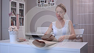 Young woman folding and cutting wrapping paper