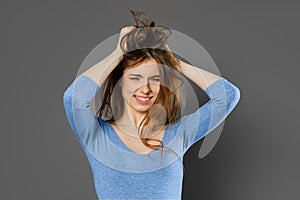 Young woman fooling around and mussing her hair with her hands