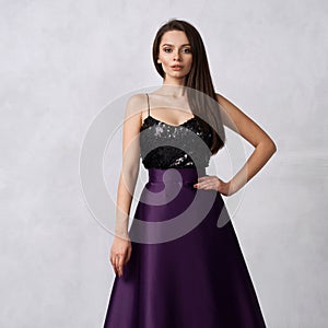 Young woman in formal dress with black sequin top and purple sa