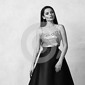 Young woman in formal dress with golden sequin top and purple sa