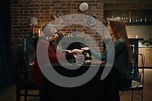 Young woman at fortune teller chiromancer consultation side view shot