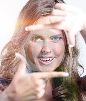 Young woman frame her face with hands