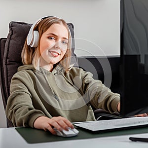 Young woman freelancer busy working remote from home or have video game leisure using pc computer in living room