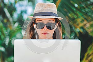 Young woman freelancer working in laptop on the beach. Freelance work