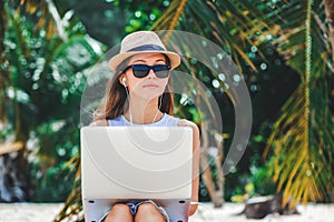 Young woman freelancer working in laptop on the beach. Freelance work