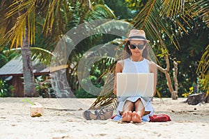 Young woman freelancer working in laptop on the beach. Freelance work photo