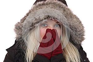 Young woman freezing in the cold in winter with gloves and cap