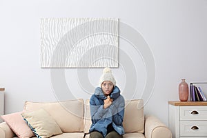 Young woman freezing under air conditioner