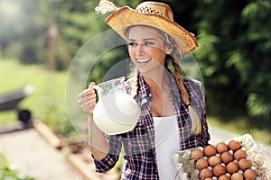 Young woman with fresh organic eggs and milk