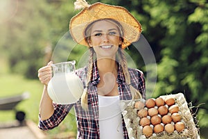 Young woman with fresh organic eggs and milk