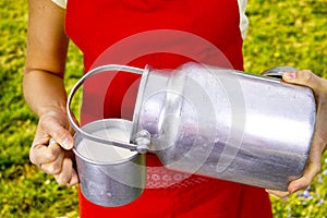 Young woman with fresh organic farm cowmilk in aluminum milk can