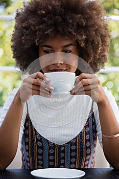 Young woman with frizzy hair having coffee