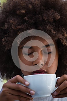 Young woman with frizzy hair smelling coffee
