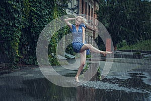 Young woman frolics in the summer rain