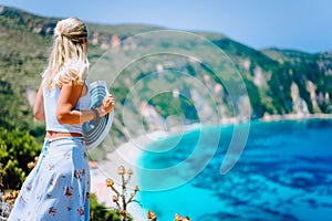 Young woman in front of Petani beach Kefalonia admiring highly excited picturesque panorama of emerald bay of