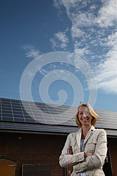 Young woman in front of solar-powered house photo