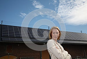 Young woman in front of solar-powered house
