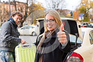 Young woman in front of taxi