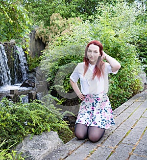 Young woman in front of a waterfall II