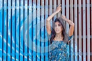 Young woman in front of a wooden palisade