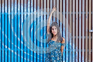 Young woman in front of a wooden palisade