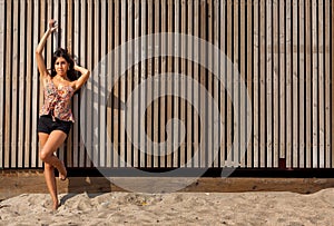 Young woman in front of a wooden palisade