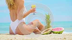 Young Woman with fruits Relaxing on the Beach.