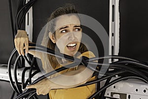 Young woman with frustation face having problems rolled up in electrical wiring tubes while building her own camper van