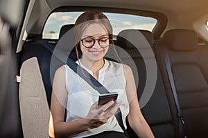 Young woman  with  gadget smartphone sitting in modern car