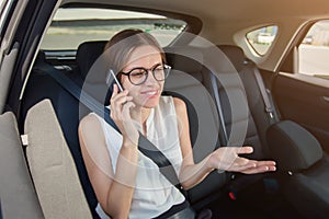 Young woman  with  gadget smartphone sitting in modern car